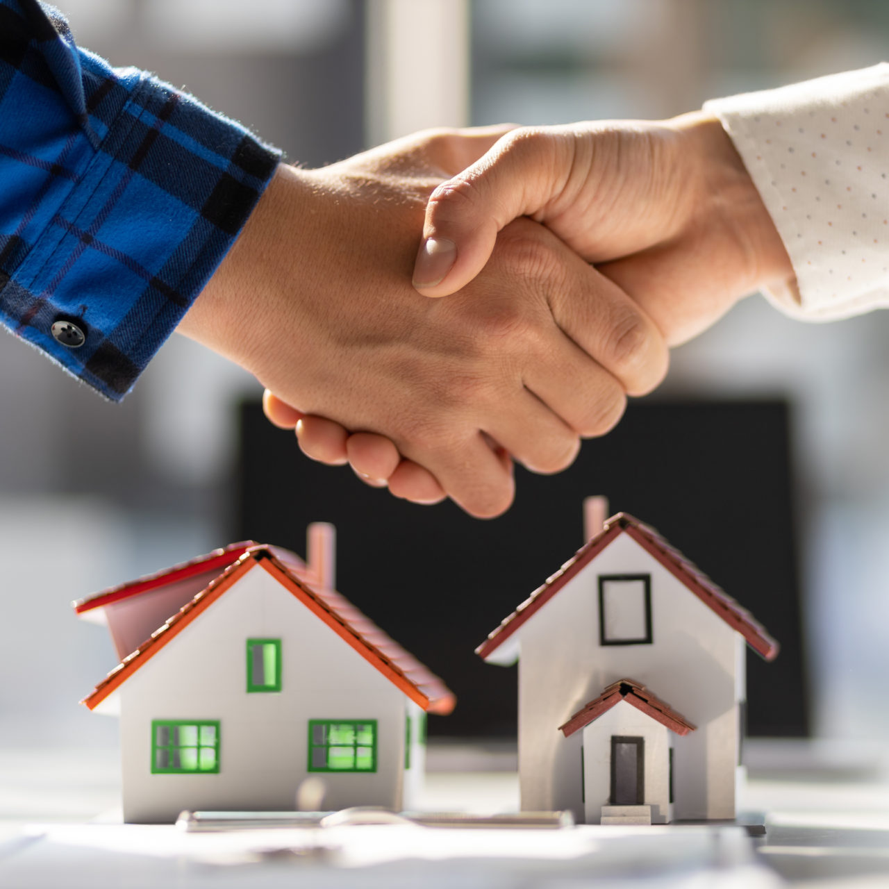 Real estate agents shake hands after the signing of the contract agreement is complete.